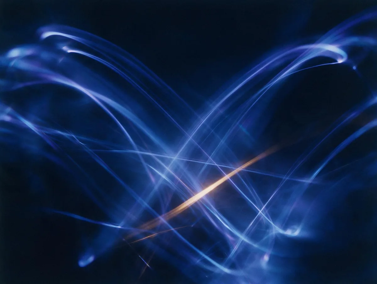 Abstract indigo light trails crossed by a single warm amber streak